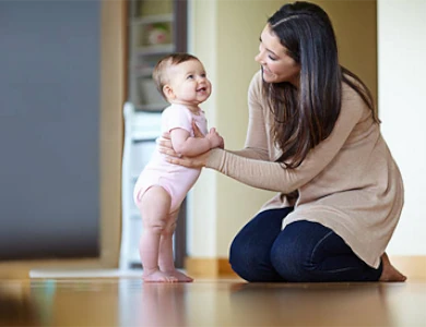 dziewięcio miesięczny niemowlak staje na nogach